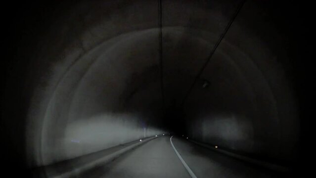電灯の無い暗いトンネルを走る車載カメラ
