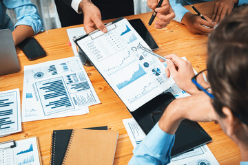 Diverse group of business analyst team analyzing financial data report paper on office table. Chart and graph dashboard by business intelligence analysis for strategic marketing planning Habiliment - obrazy, fototapety, plakaty