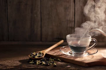 Schilderijen op glas Cups of hot butterfly pea tea are arranged on a wooden floor. Healthy Herbal Drink Concept Traditional Antioxidant Drinks © WIROT