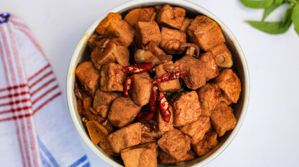 soy sauce tofu in a bowl isolated on white background. traditional Javanese side dish