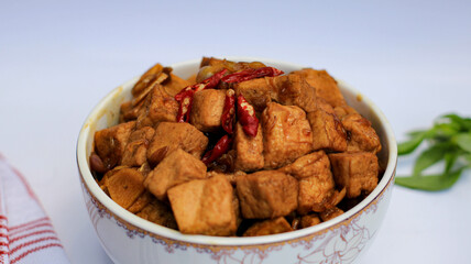 soy sauce tofu in a bowl isolated on white background. traditional Javanese side dish