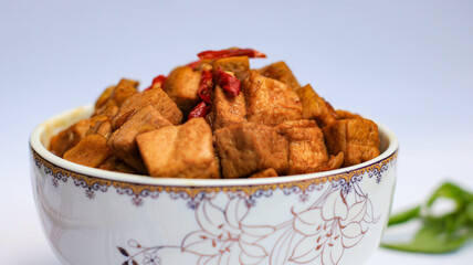 soy sauce tofu in a bowl isolated on white background. traditional Javanese side dish