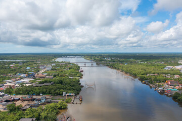 Aerial view of fishing trap net in canel with fisherman urban city village town houses, lake or river. Nature landscape fisheries and fishing tools at Pak Pha, Songkhla, Thailand. Aquaculture farming