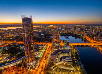Obraz premium Yekaterinburg city and pond aerial panoramic view at summer or early autumn night. Night city in the early autumn or summer.