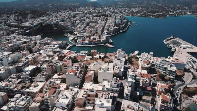 birds-eye view of Agios Nikolaos, pretty and magnificent coastal city with small white buildings, Crete, Greece. High quality 4k footage