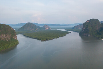 Fototapeta premium Aerial top view of a garden park with green mangrove forest trees, river, pond or lake. Nature landscape background, Thailand.