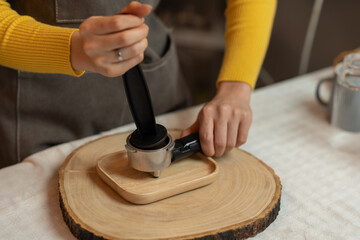 Fototapeta premium Owner, Asian woman holding coffee powder while grinding to prepare coffee in a cafe Baristas use coffee machines to make coffee for customers. Freelance Startup Business Idea or SME
