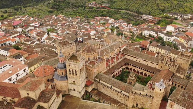 Aerial photo of residential buildings with tiled roofs in Guadalupe, Spain. Monastery of Saint Mary visible from above.