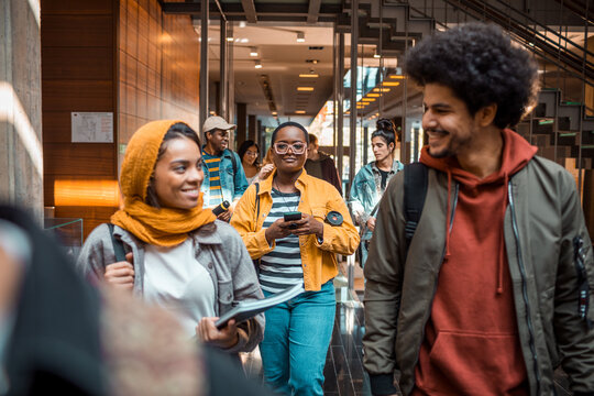 Young And Diverse Group Of Students And Friends Walking In A College Or University Hallway