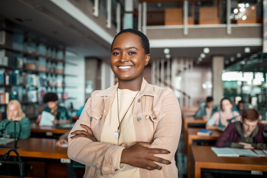 Smiling portrait of a happy african american female student in a college or university library