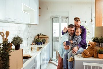Young family taking a selfie after moving in their new home apartment