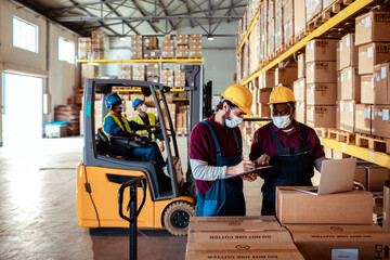 Diverse group of warehouse workers wearing covid19 or coronavirus masks working in a warehouse