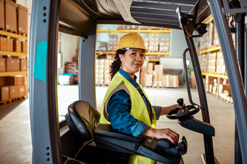 portrait of a female african american forklift driver working in a warehouse