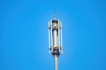 a cellphone signal transmitting tower with a clear blue sky background