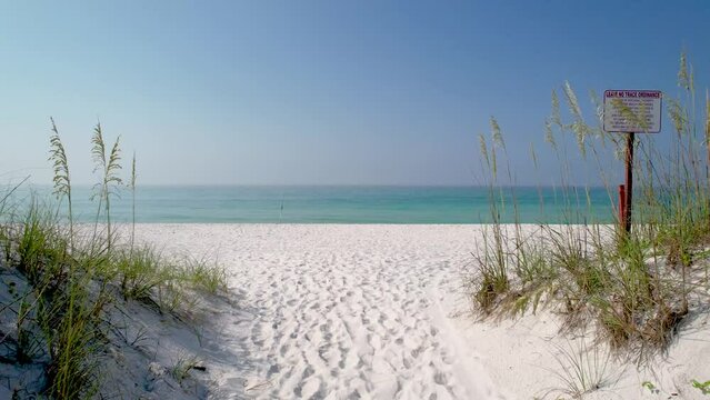 AWalk to though sand dunes with sea oats on white sand beach of Pensacola Florida on the Clear waters of the Gulf of Mexico on a bright sunny summer day