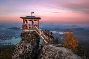 Jetrichovice, Czech Republic - Aerial view of Mariina Vyhlidka (Mary's view) lookout with foggy Czech autumn landscape, golden foliage and colorful sunrise sky in Bohemian Switzerland National Park - obrazy, fototapety, plakaty