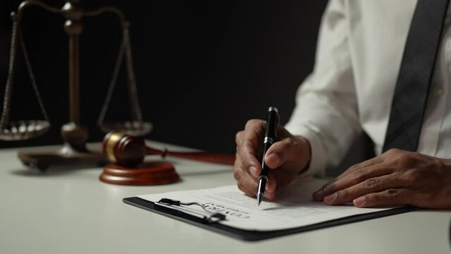 Young lawyer or legal advisor is reading and carefully checking the validity of documents and investment agreements for signing contracts managing justice concepts.