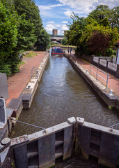 narrowboat exiting a lock on the River Stort near Harlow in England showing a closed lock gate in...