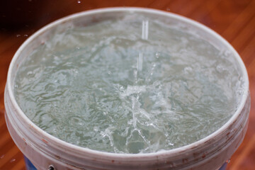 Rain is falling in a bucket full of water.Rainwater harvesting.Rainy season is coming.