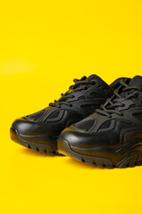 Black new sport sneakers on yellow background