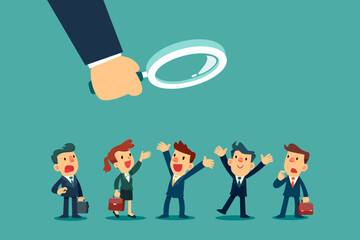 big hand with magnifying glass looking at group of business people