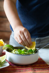 Obraz na płótnie Canvas boy in blue shirt dipping chip into guacamole