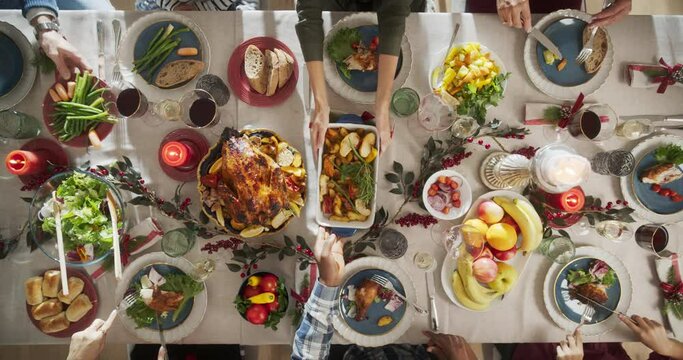 Top Down View with Anonymous Family, Children, Friends Gathered at Home for a Festive Christmas Dinner. Diverse People Enjoy Delicious Turkey Feast and Share Stories. Cozy Holiday Celebration
