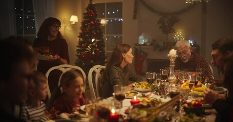 Families with Kids and Friends Gather for a Joyful Christmas Dinner with Beautifully Roasted Turkey. Home Is Filled with Festive Winter Atmosphere, Grandmother Bringing the Main Course to the Table