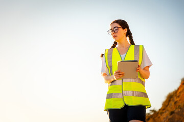 Inspection environmentalist. Bottom view of volunteer woman wearing vest and using pad for analyzing water. In background is sky. Copy space. Concept of air pollution and ecology