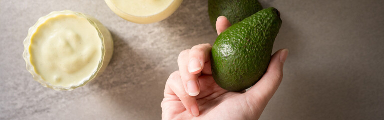 web banner healthy breakfast with top view woman hand hold avocado put on table