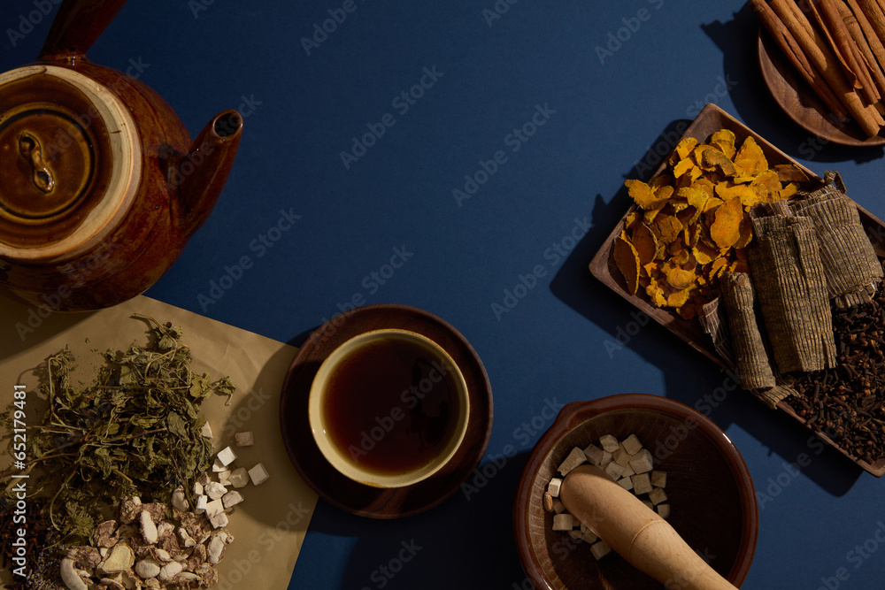 Poster An earthen pot, a bowl of tonic arranged with Cinnamon, Dried turmeric, Eucommia bark and Cloves. Herbs for health enhancing, very useful in traditional medicine