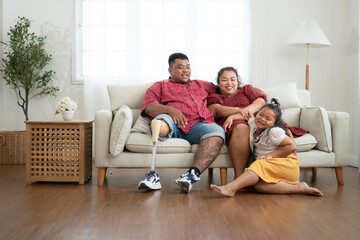 A plus size family with a father wearing a prosthetic leg, Resting and talking with daughter on the weekly holiday, in the living room of the house.