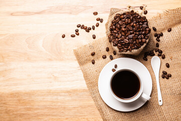 Flat lay, top view Black coffee in coffee cup with coffee beanand on wooden table