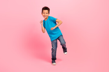 Full length photo of cute carefree small boy wear blue t-shirt dancing having fun isolated pink...