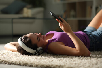 Happy woman with headphone on the floor