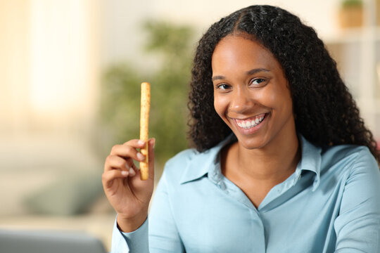 Happy Black Woman Showing Snack At Home