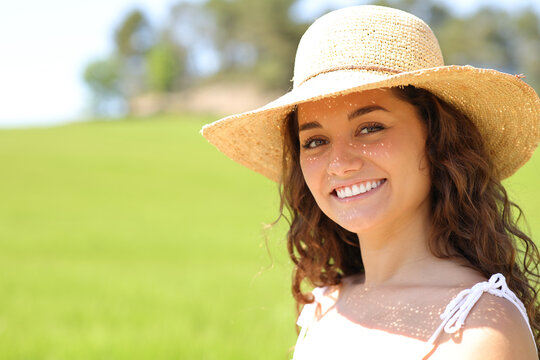 Happy woman with pamela in a field smiling at camera