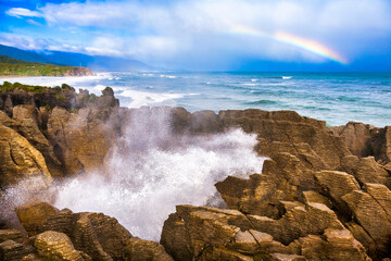 Putai blowhole at the famous Pancake Rocks, Rainbow over sea at Dolomite Point, near Punakaiki,...