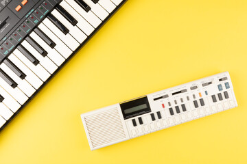 Vintage electronic keyboard synth piano on yellow background