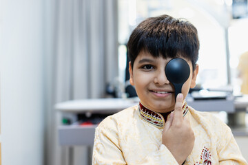 Indian boy examining eyesight checkup vision farsightedness  examines ophthalmological hospital....