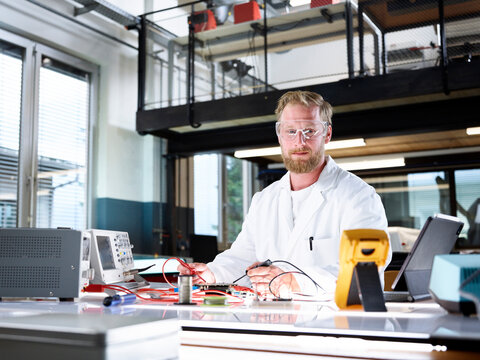 Smiling scientist with electronic equipment in laboratory