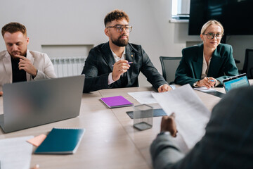 Back view of unrecognizable African businessman reading contract document, preparing to sign contract of sale, thinking considering risks, analyzing financial report. Executive checking legal document