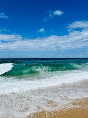 Fototapeta na wymiar Waved seashore, sea water foam, powerful and fresh seascape, blue horizon
