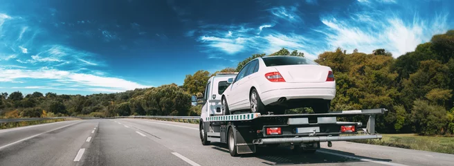 Foto op Plexiglas Car Service Transportation Concept. Tow Truck Transporting Car Or Help On Road Transports Wrecker Broken Car. Auto Towing, Tow Truck For Transportation Faults And Emergency Cars . Tow Truck Moving In © Grigory Bruev