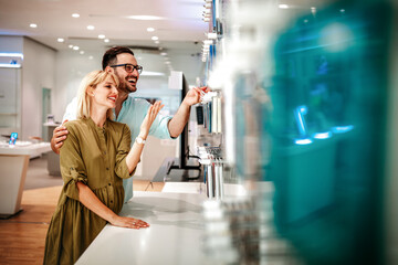Shopping a new digital device. Happy couple buying a smartphone in store.