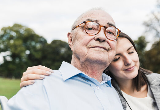 Portrait of self-confident senior man with his granddaughter in a park