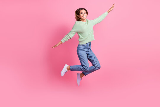 Full body size photo of jumper careless woman brown hair flying hands wings free atmosphere shopper isolated on pink color background