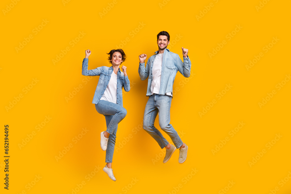 Poster photo of cheerful two buddies jumping enjoying shopping isolated in vivid color background