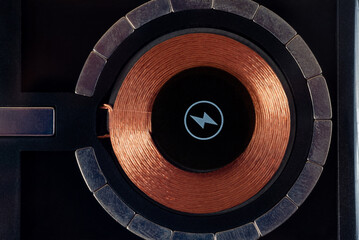 Wireless charger, top view, close up. The electromagnetic coil and magnets are visible. - obrazy, fototapety, plakaty