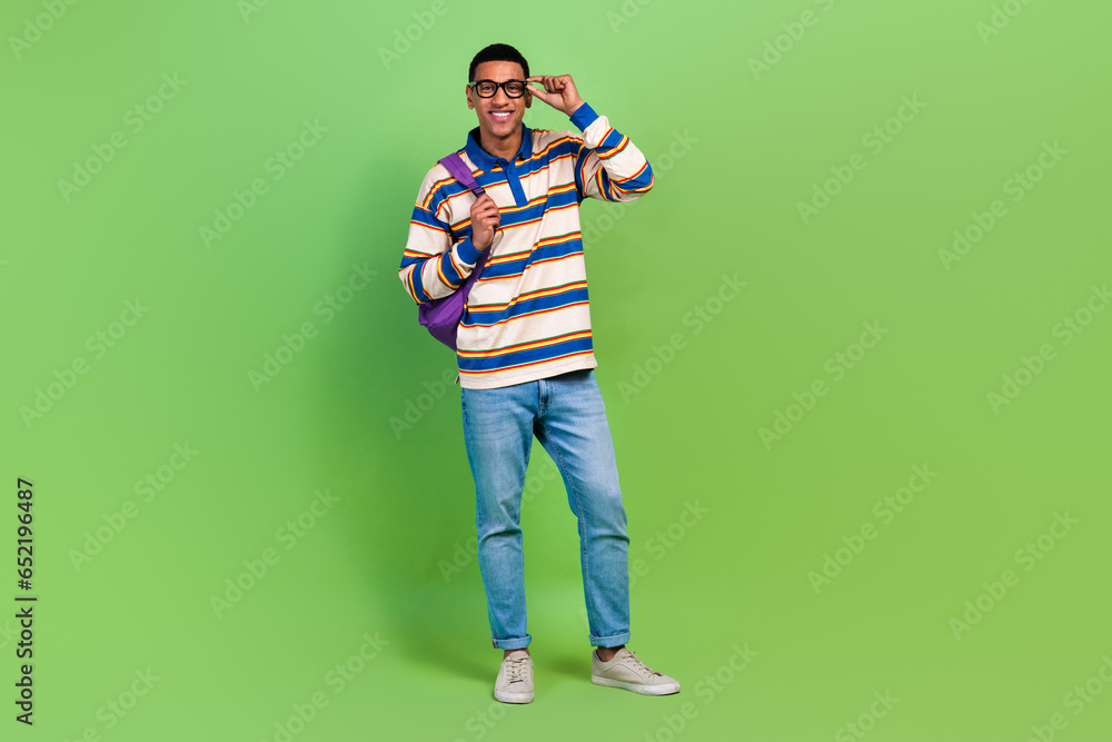 Sticker Full body photo of young man smile touch eyeglasses posing model wear rucksack back to cambridge college isolated on green color background